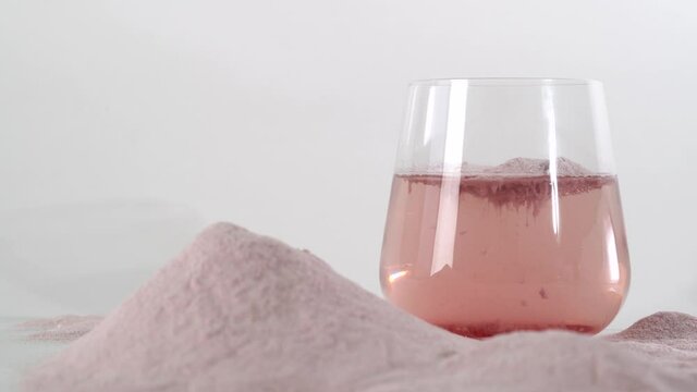 Super food. Natural strawberry collagen protein powder in glass of water for skin regeneration. Trendy food additives. Healthy and anti age concept.