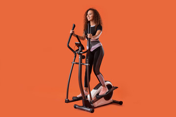 Beautiful young woman with elliptical machine on color background