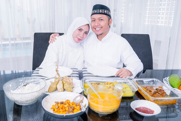 Happy Muslim couple embracing in dining table