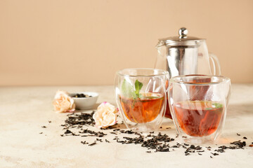 Teapot and cups of hot beverage on grunge background