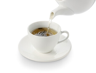 Pouring of green tea from teapot into cup on white background