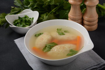 Griessnockerlsuppe. Clear Soup with Semolina Dumplings in a white bowl. German food.  Bavarian cuisine.