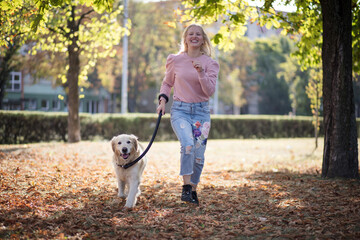 Woman running with dog in the park.
