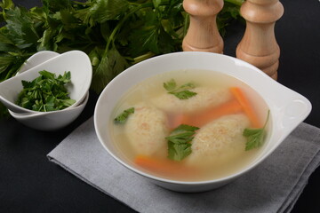 Griessnockerlsuppe. Clear Soup with Semolina Dumplings in a white bowl. German food.  Bavarian cuisine.