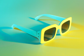 Stylish sunglasses on color background