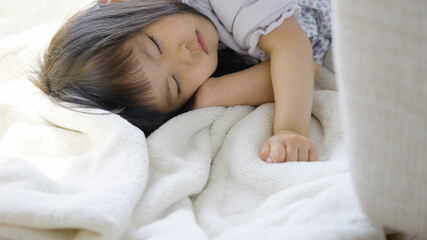 Fototapeta na wymiar 家で昼寝をする3歳の子供