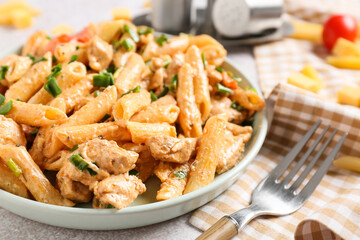 Plate with cajun chicken pasta on table, closeup