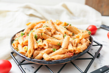 Plate with cajun chicken pasta on light background