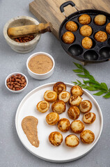 Suji appe or appam served on a appam pan with peanuts and tamarind chutney