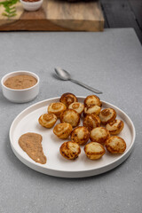 Suji appe or appam served on a appam pan with peanuts and tamarind chutney