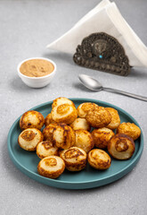 Suji appe or appam served on a appam pan with peanuts and tamarind chutney
