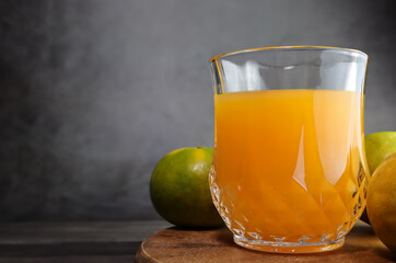 Glass of fresh orange juice on a dark backgroun.