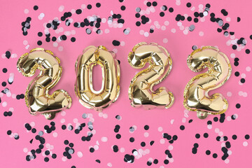 New Year 2022. Foil balloons numbers 2022 on a pink background. New Year Christmas.