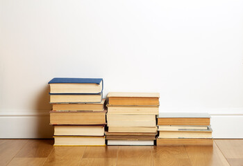 Home education concept. Books on the background of a white wall in an empty room. Reading and study.
