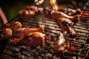 chicken drumsticks are grilled on a barbecue grill