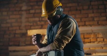 Man drinking hot beverage on construction site