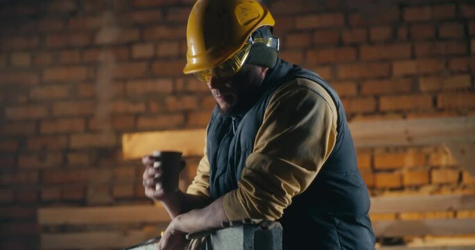 Man drinking hot beverage on construction site