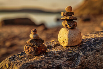 A cairn on a beach with sand in the blurry background