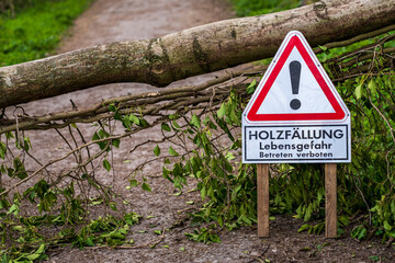 Sign: 'Holzfaellung Lebensgefahr Betreten verboten' (German for 'Logging, Risk of death, Do not enter'), with a tree trunk blocking the footpath