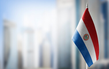A small flag of Paraguay on the background of a blurred background