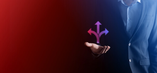 Businessman in a suit holds a sign showing three directions. in doubt, having to choose between three different choices indicated by arrows pointing in opposite direction concept. three ways to choose