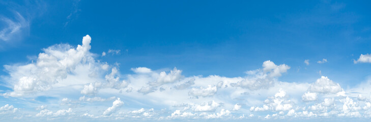 Panorama image Bright sky with fluffy clouds in white with an area of blue sky to add text for advertisement.