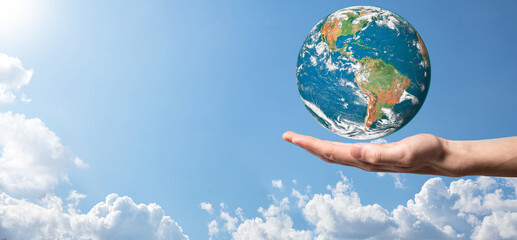 Hands holding a planet, earth on a background of nature blue sky with beautiful white clouds and sunlight.Sustain earth concept. Elements of this image furnished by NASA