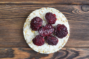 cereal breakfast crisp bread with blackberry isolated on a wooden textured table flat lay, diet, vegetarianism, healthy food