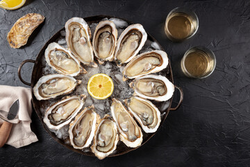 Oysters. A dozen of raw oysters with wine and lemons, overhead flat lay shot