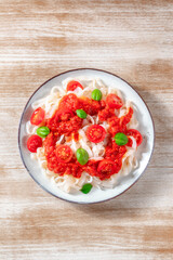Konjac pasta with tomato sauce, shot from the top on a wooden background