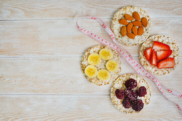 cereal breakfast crisp breads with strawberries, almonds nuts, banana fruit and blackberries on wooden textured table with copy space text