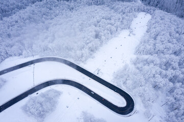 Aerial Winter landscape in Ski Resort Rosa Khutor. TMountain road from a bird's eye view. Krasnaya Polyana, Sochi, Russia