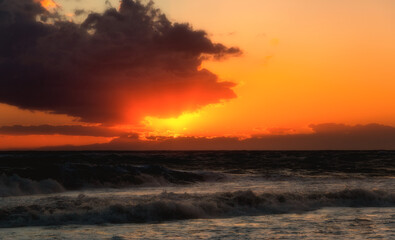 Sunset over the ocean. Stormy weather.