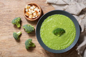 plate of broccoli soup on a wooden background