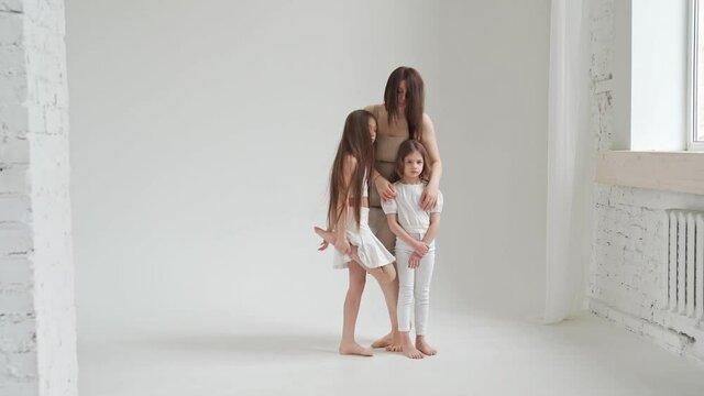 Mom and daughters pose in a white photo studio for a photo shoot. backstage. 