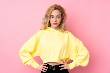 Young blonde woman wearing a sweatshirt isolated on pink background angry