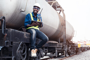 African male engineer control a the train on railway with talking by radio communication or walkie talkie with using tablet