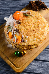Traditional napoleon cake decorated with tangerines and christmas cookies. Christmas or New Year baking.
