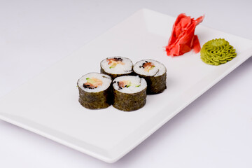 Japan sushi rolls isolated on white background served on a white plate.