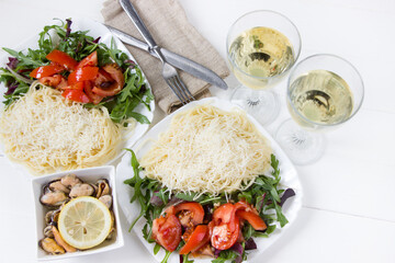Pasta with gran padano cheese with arugula and tomato salad, mussels and white wine