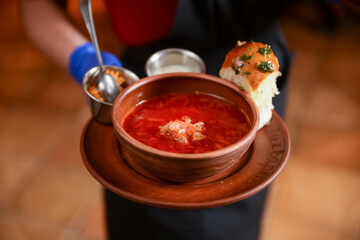 Ukrainian traditional borsch. Russian vegetarian red soup in a bowl served by waiter in restaurant or diner.
