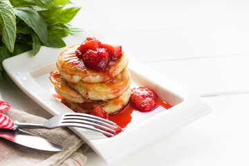 Pancakes with fresh strawberry sauce.Healthy breakfast, white wooden board