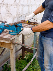 Diligent efficient serious glad worker makes repairs  with electric tools  hammer and  pliers in backyard