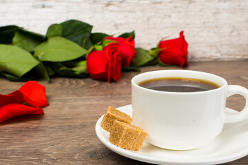 Fototapeta na wymiar red roses and coffee cup on wooden table, love or romantic good morning concept