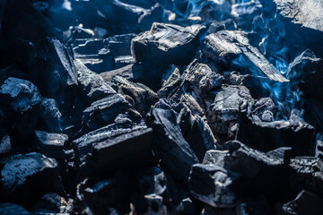 Black coals in the grill close-up. The effects of fire, ashes.