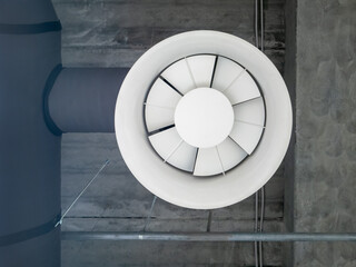 Ventilation and air conditioning system in industrial or commercial premises, close up. Ventilation big fan, pipes, hoods, under the ceiling. Monochrome black and white image.