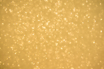 Gold glitters background. shimmering blur spot lights Bokeh Shiny gold light background.