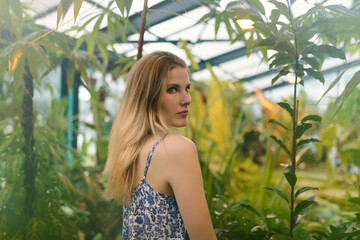 Portrait of beautiful young woman among tropical plants.