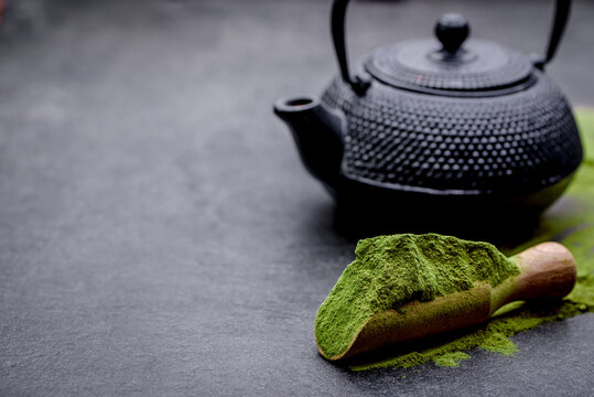 Powdered green tea and set for matcha on black background
