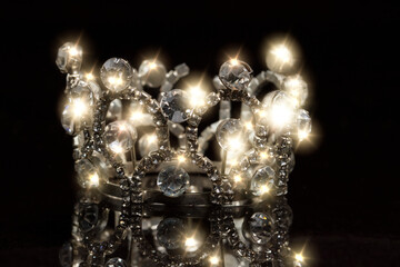 Jewelry crown with shiny stones on a black background.